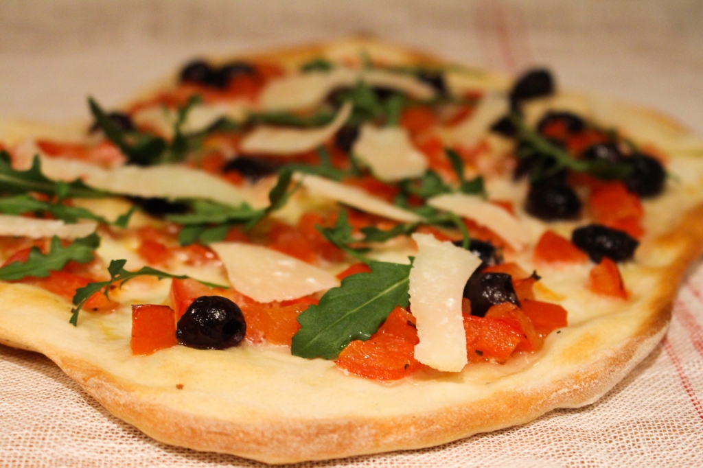 Pizza met tomaat, olijven en rucola