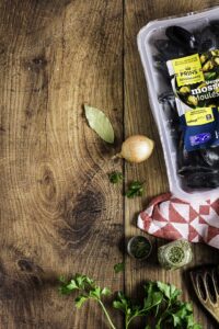 Mosselen met MSC label op tafel met ui, laurier, tijm en peterselie