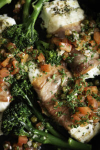 Kabeljauwhaasje in parmaham met sauce vierge en parmezaanpuree-close-up