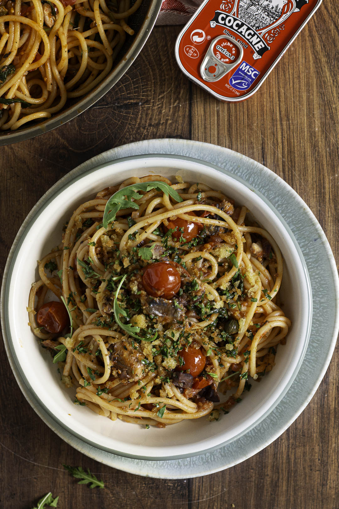 Pasta puttanesca met sardienen topshot, met blikje sardienen Cocagne erbij